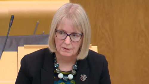 Beatrice Wishart MSP standing at lectern in Scottish Parliament chamber