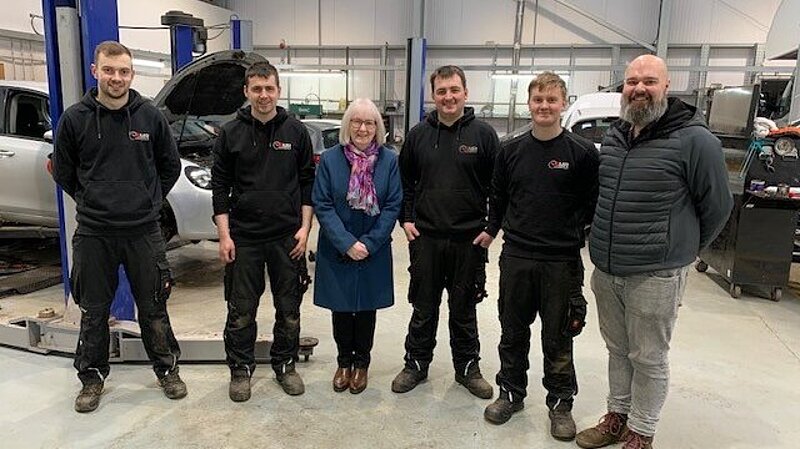 Beatrice stands with apprentices at Shetland MOT & Repair, Tingwall