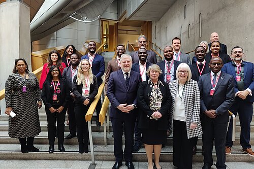 Beatrice Wishart MSP stands surrounded by attendees of the summit