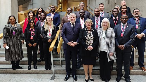 Beatrice Wishart MSP stands surrounded by attendees of the summit